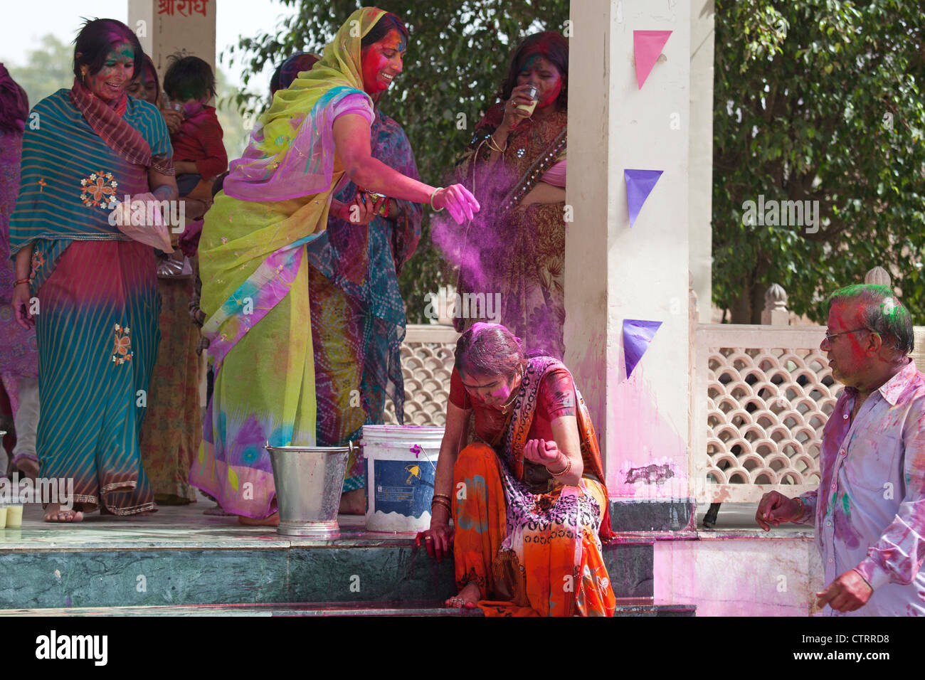 Women covered in colourful dye celebrating the Holi festival, Festival of Colours in Mathura, Uttar Pradesh, India Stock Photo