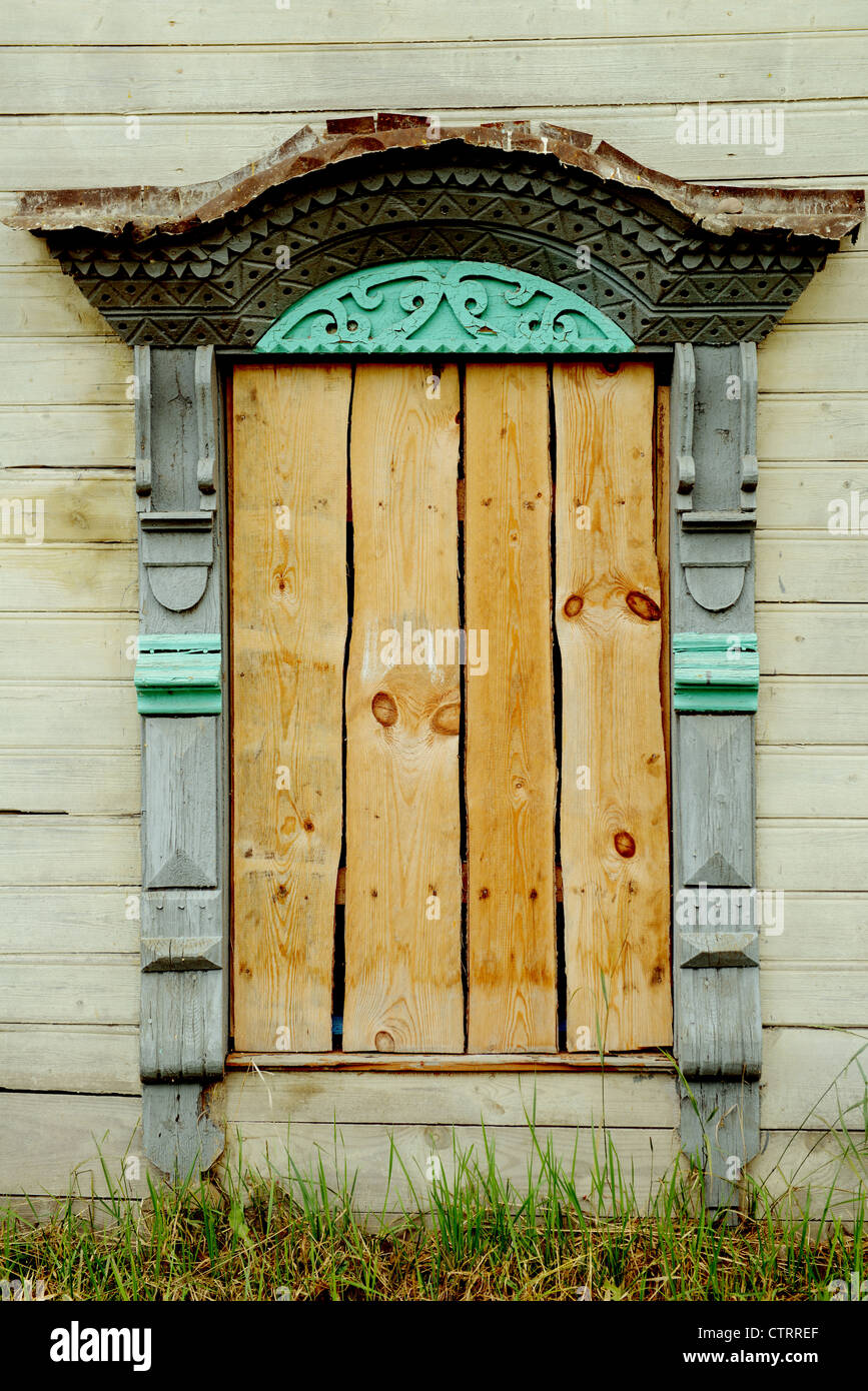 Traditional old Russian window carved plat band of thrown wood house Stock Photo