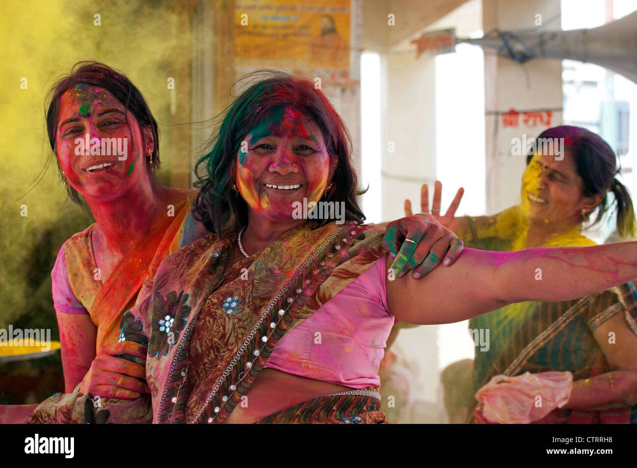 Women covered in colourful dye celebrating the Holi festival, Festival of Colours in Mathura, Uttar Pradesh, India Stock Photo