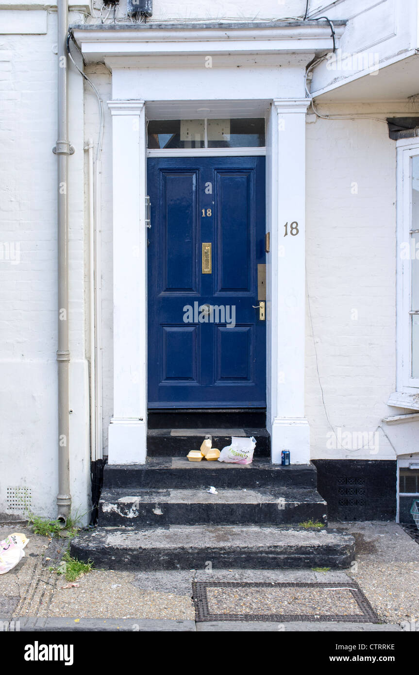 Empty takeaway food boxes and packaging left on doorstep in a UK street Stock Photo