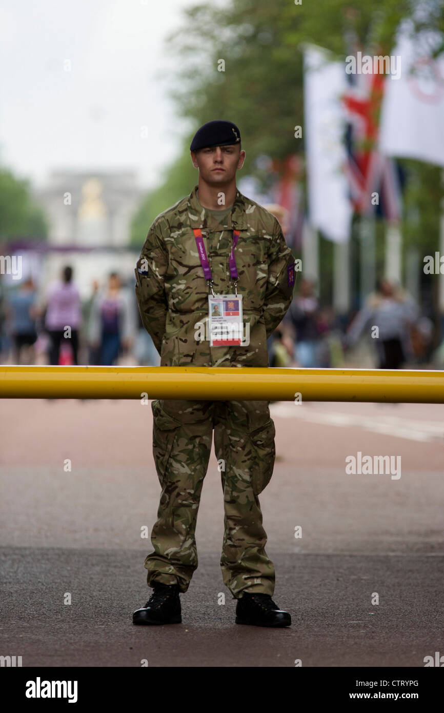A soldier of the British army stand guarding the entrance to the volleyball venue in central London next to the IOC rings logo on day 4 of the London 2012 Olympic Games. A further 1,200 military personnel are being deployed to help secure the 2012 Olympics in London following the failure by security contractor G4S to provide enough private guards. The extra personnel have been drafted in amid continuing fears that the private security contractor's handling of the £284m contract remains a risk to the Games. Stock Photo