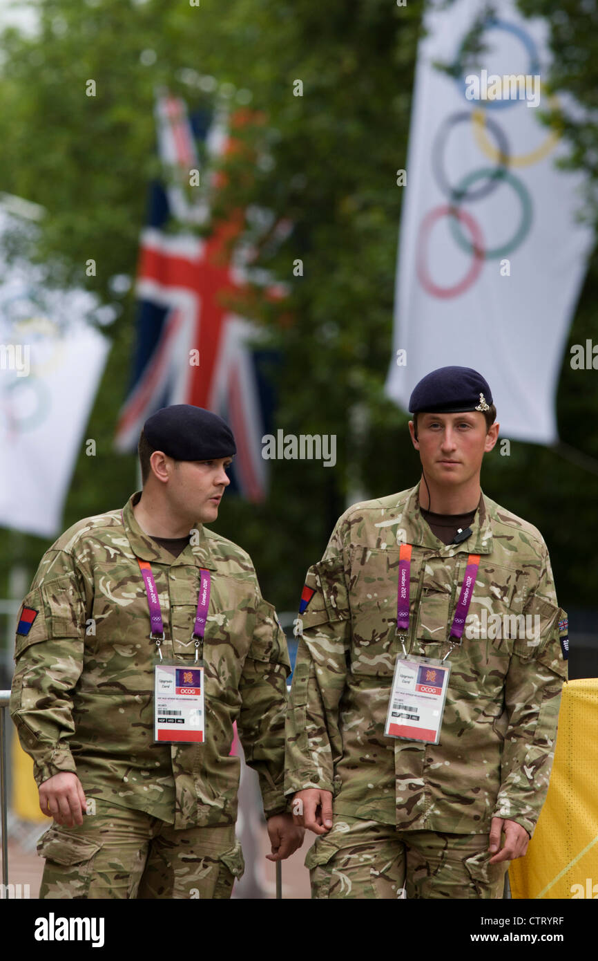 Soldiers of the Royal Artillery regiment in the British army stand guarding the entrance to the volleyball venue in central London next to the IOC rings logo on day 4 of the London 2012 Olympic Games. A further 1,200 military personnel are being deployed to help secure the 2012 Olympics in London following the failure by security contractor G4S to provide enough private guards. The extra personnel have been drafted in amid continuing fears that the private security contractor's handling of the £284m contract remains a risk to the Games. Stock Photo