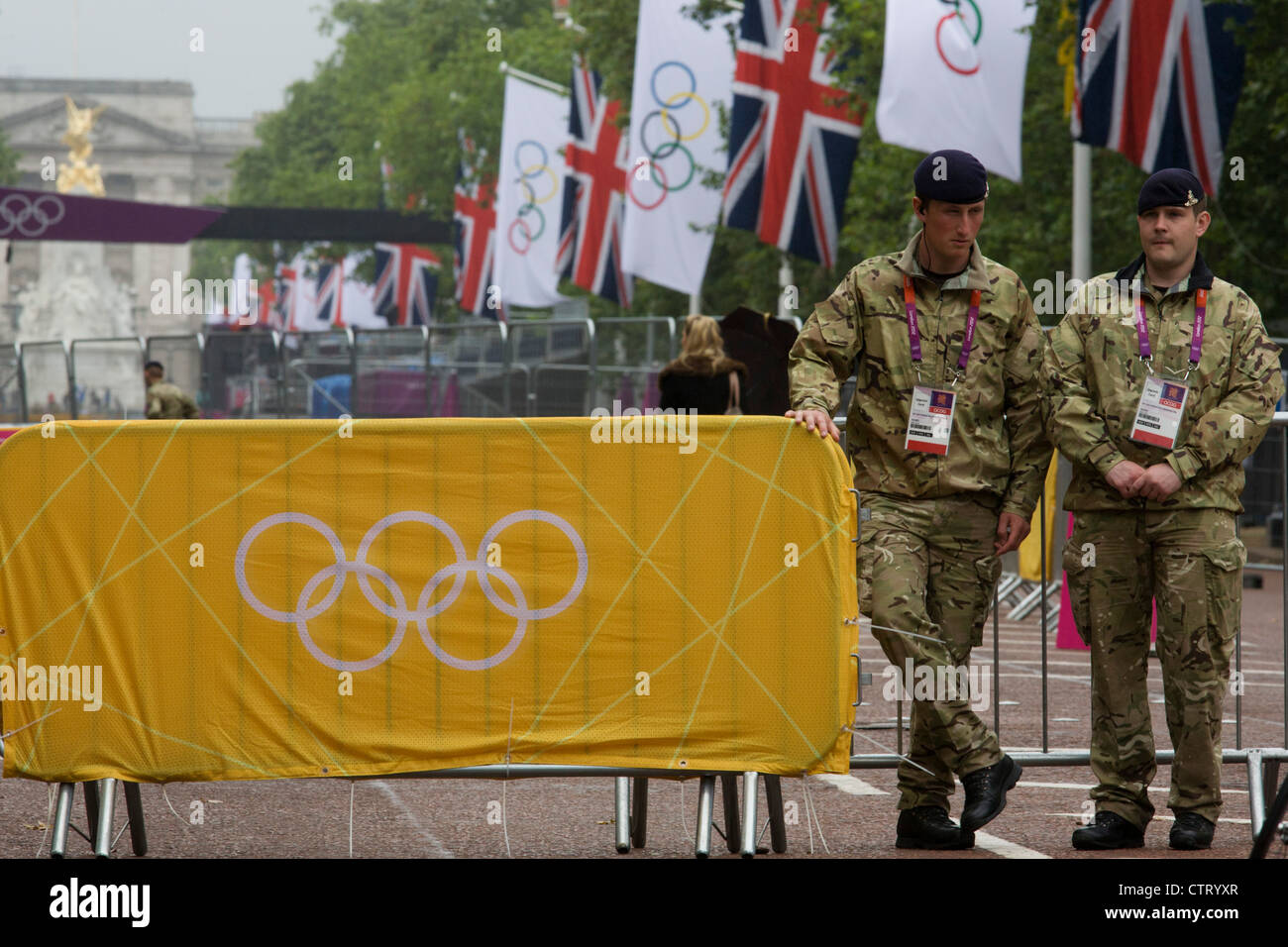 Soldiers the Royal Artillery regiment in the British army stand guarding the entrance to the volleyball venue in central London next to the IOC rings logo on day 4 of the London 2012 Olympic Games. A further 1,200 military personnel are being deployed to help secure the 2012 Olympics in London following the failure by security contractor G4S to provide enough private guards. The extra personnel have been drafted in amid continuing fears that the private security contractor's handling of the £284m contract remains a risk to the Games. Stock Photo