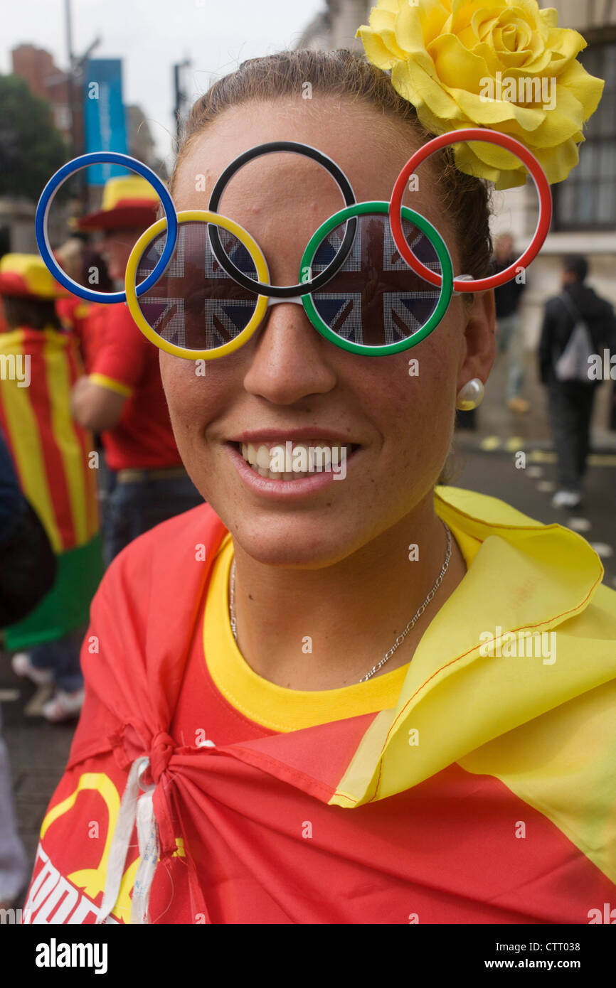 Wearing Olympic ring glasses, a lady sports fan tours central London during  a break watching events during the London 2012 Olympics. Wearing their  country's national colours the friends enjoy a respite from