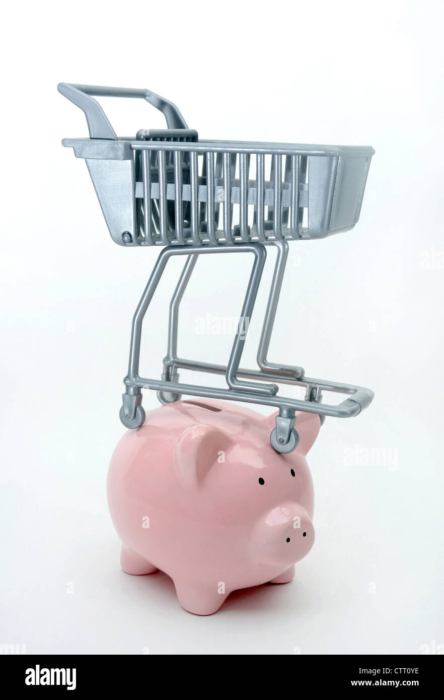 SUPERMARKET SHOPPING TROLLEY BALANCING ON PIGGYBANK RE INCOMES FOOD PRICES INCOMES HOUSEHOLD BUDGETS RISES COST OF LIVING ETC UK Stock Photo