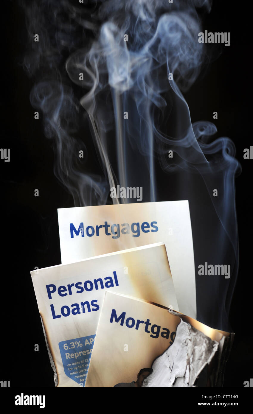 SMOKING BURNING MORTGAGE AND LOANS LEAFLETS RE MORTGAGES LOANS INCOMES HOUSE BUYERS HOME HOMEOWNERS ENDOWMENTS INTEREST  UK Stock Photo
