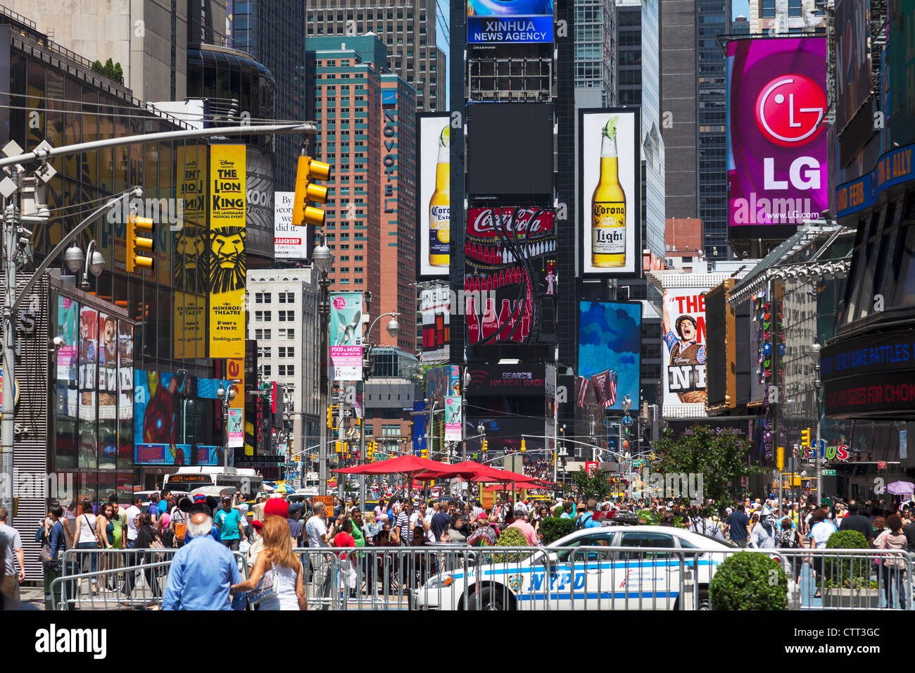 Busy Times Square in Manhattan, New York City, tourists, NYPD, bright lights and advertising hoardings fill the scene Stock Photo
