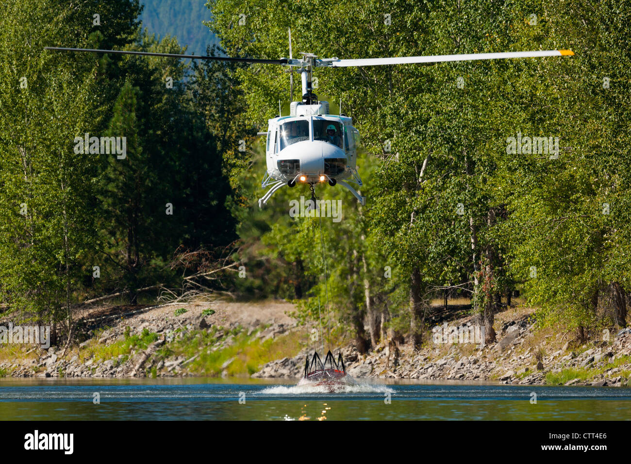 firefighting helicopter taking on a load of water from a river Stock Photo