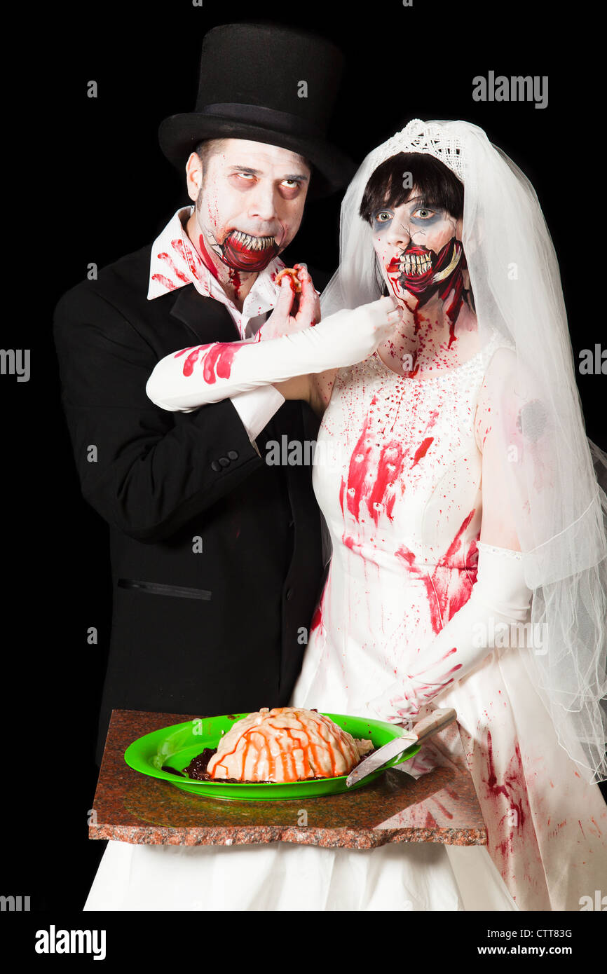 A zombie bride and groom feed each other brains at their wedding reception Stock Photo