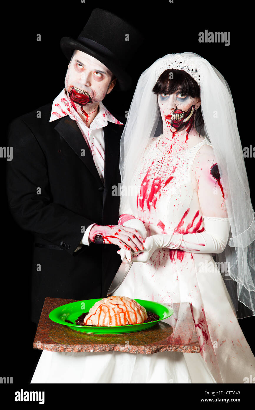 A zombie bride and groom prepare to cut into brains to celebrate their wedding Stock Photo