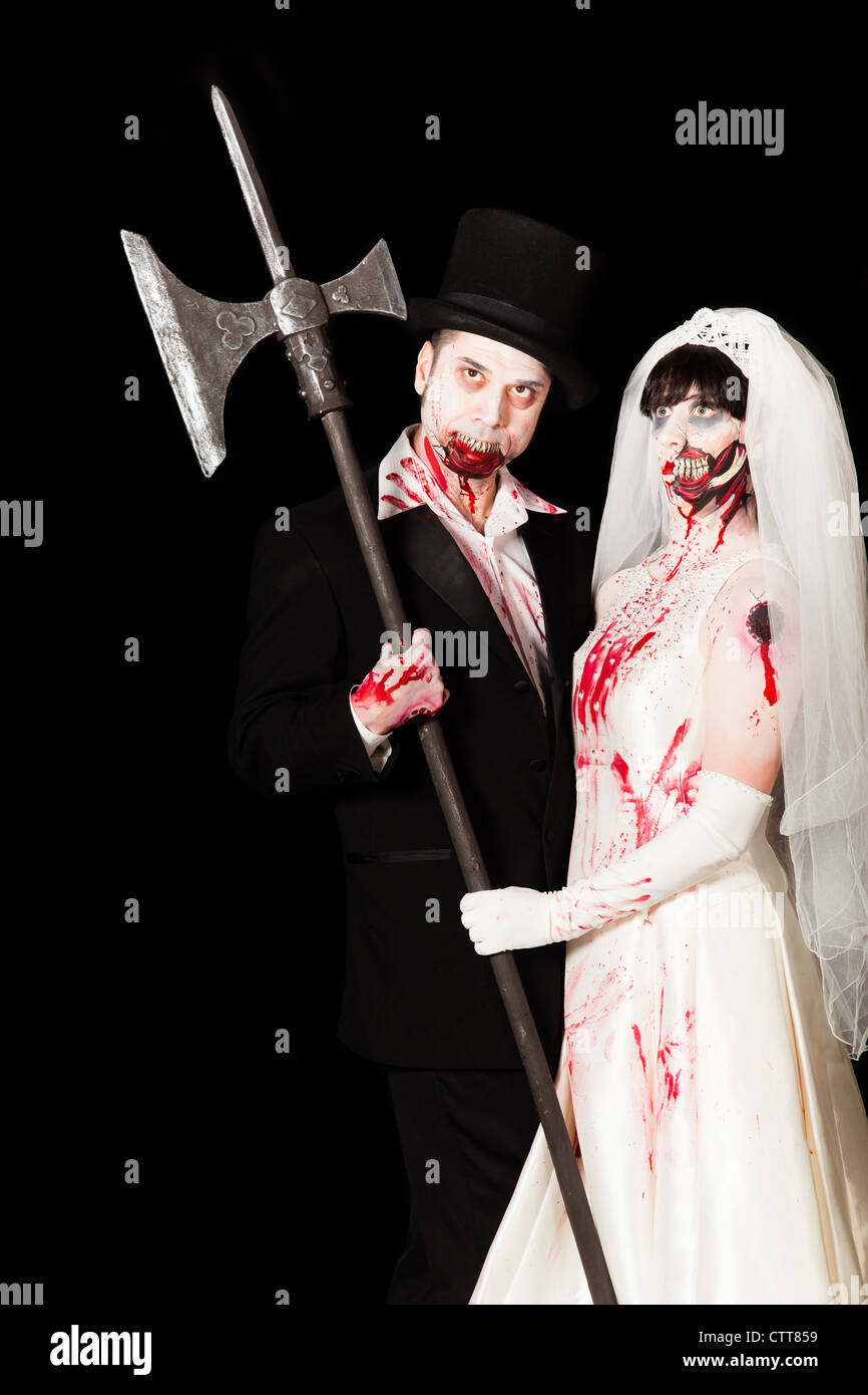 A zombie bride and groom pose with a primitive weapon Stock Photo