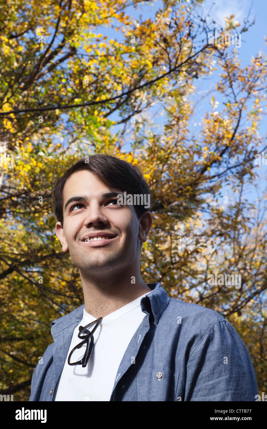 Handsome young man posing with glasses, smiling Stock Photo - Alamy