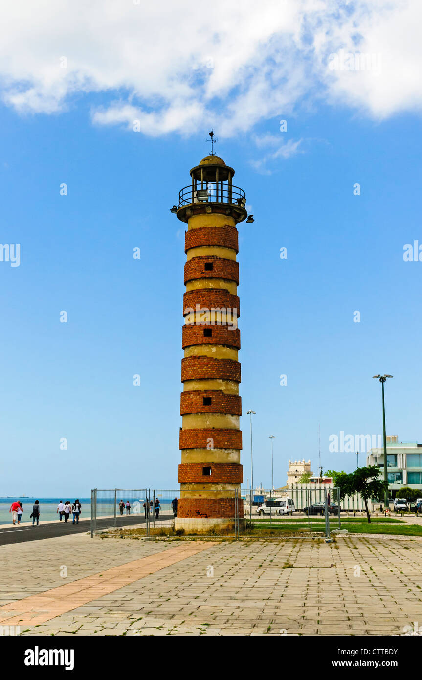 An old redbrick lighthouse located on the banks of the River Tagus between the Torre de Belem and Monument to the Discoveries Stock Photo