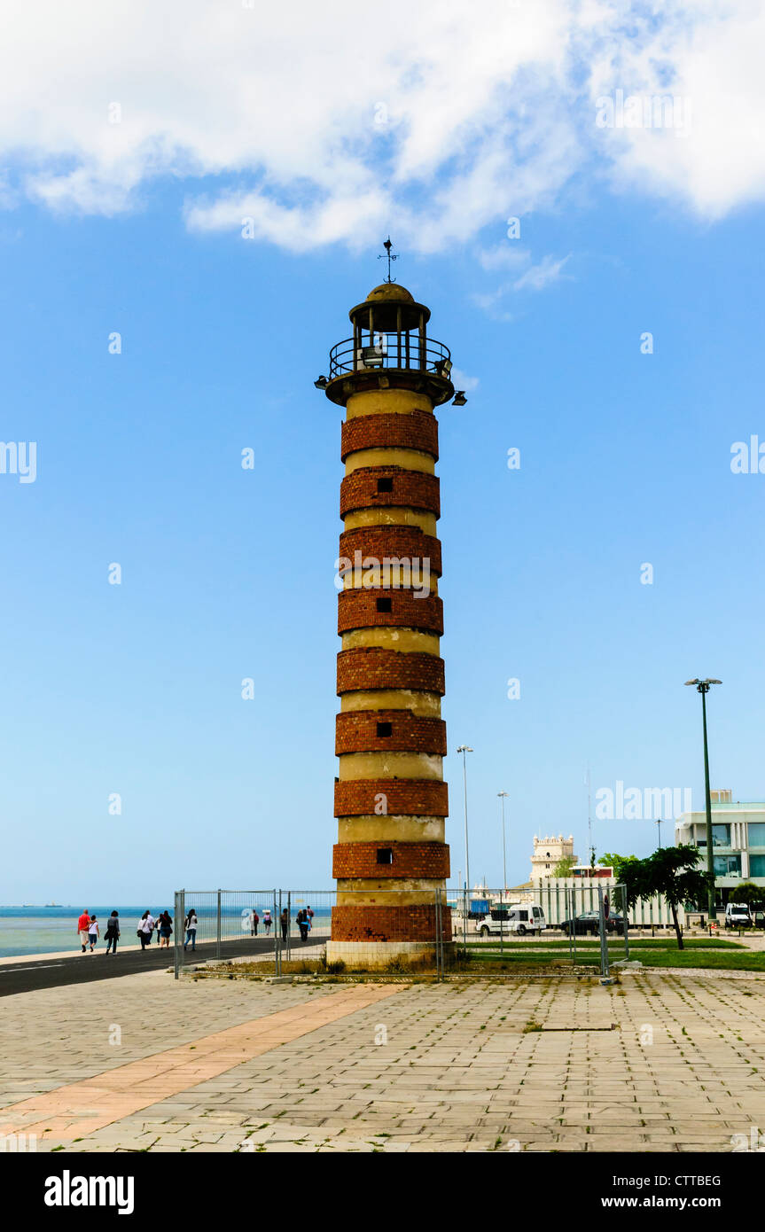 An old redbrick lighthouse located on the banks of the River Tagus between the Torre de Belem and Monument to the Discoveries Stock Photo