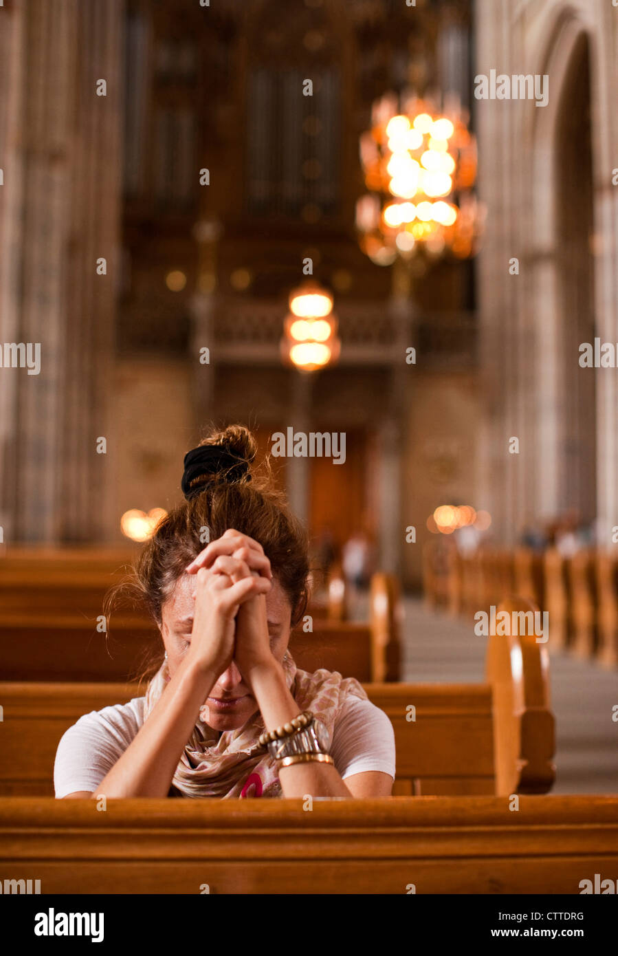A woman praying in Uppsala's cathedral. Uppsala, Sweden. Stock Photo