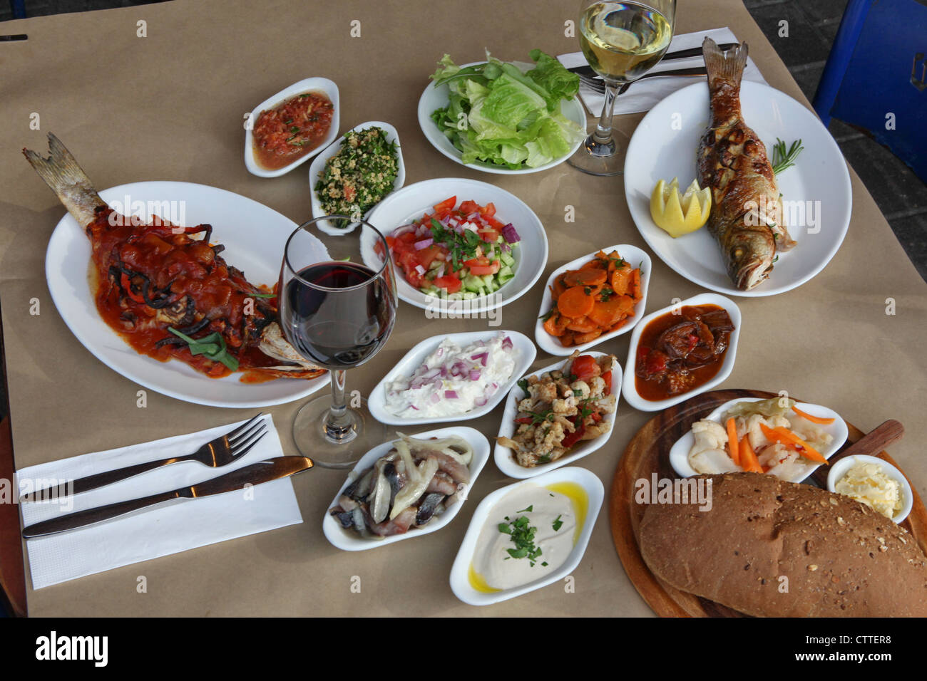 Deep fried fish and a mezze of Mediterranean Salads Stock Photo