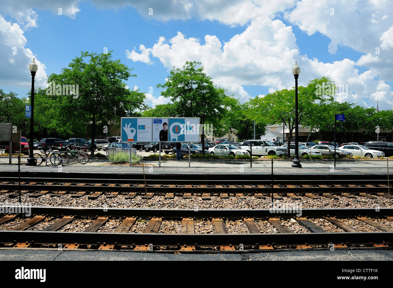 Railroad tracks and parking lot at suburban train station. Metra/Fox