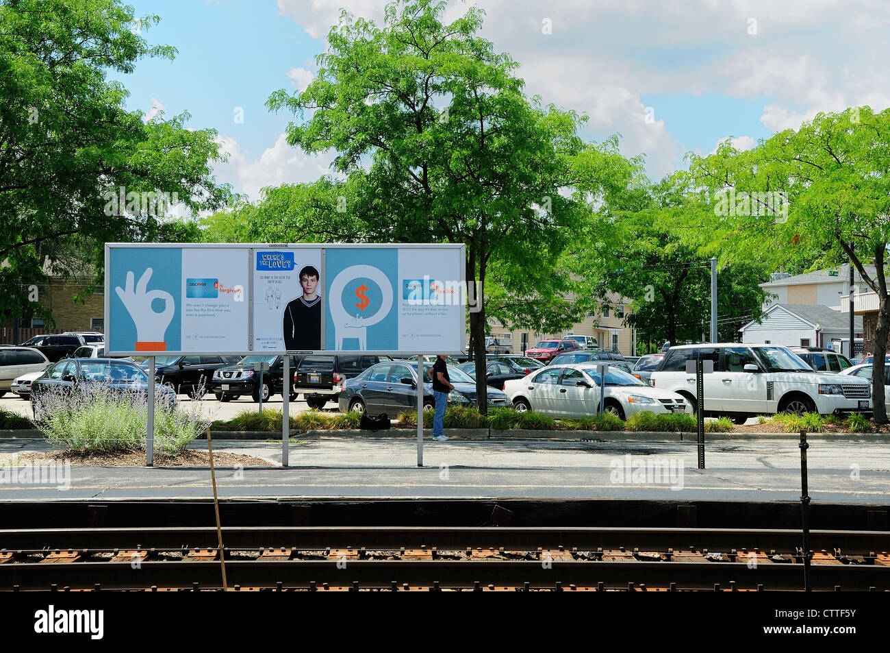 Railroad tracks and parking lot at suburban train station. Metra/Fox
