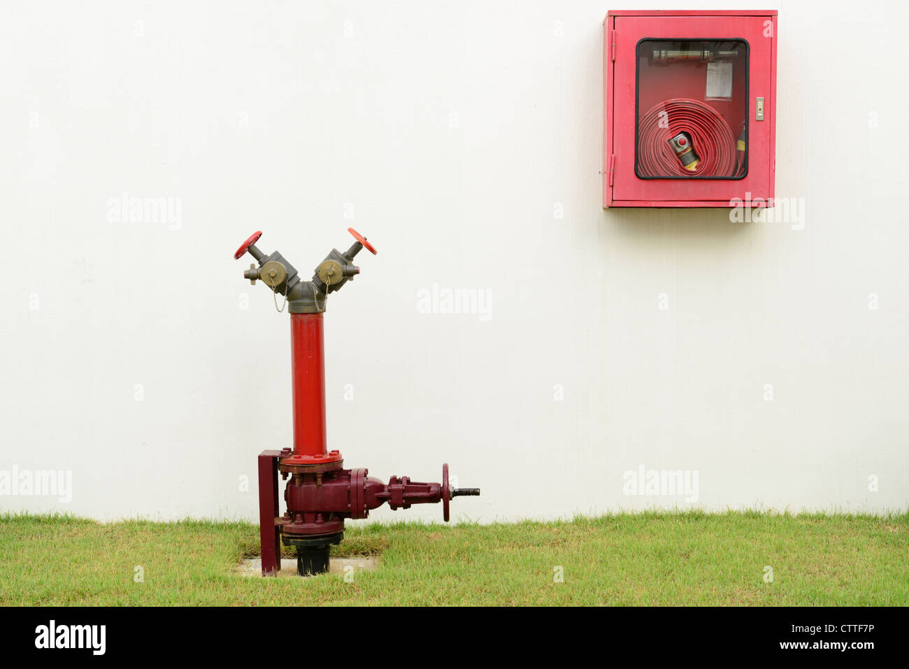 The red fire hydrant and fire hose next to the building Stock Photo