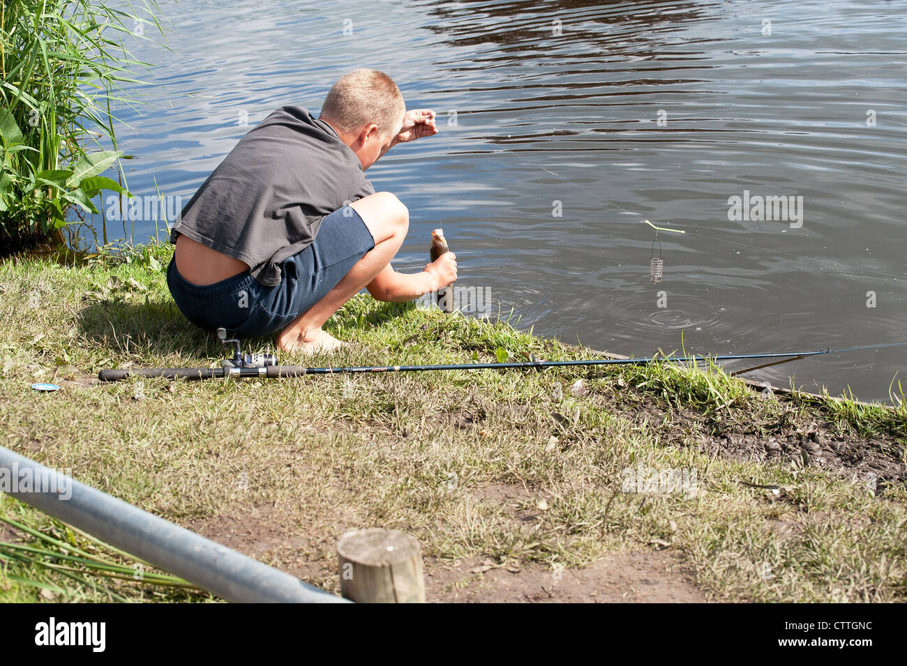 Fisherman catches a beautiful silver fish in river Stock Photo