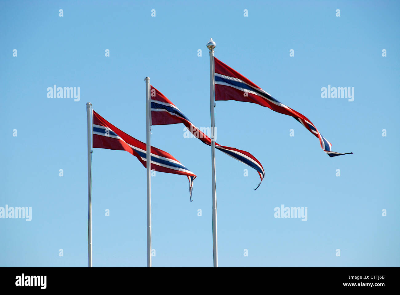 Three Norwegian pennant flags against a blue sky Stock Photo