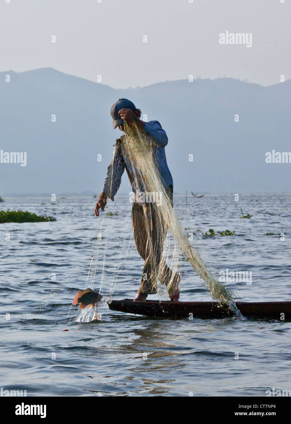 Fishing is still done in the traditonal way with small wooden boats and fishing nets - INLE LAKE, MYANMAR Stock Photo