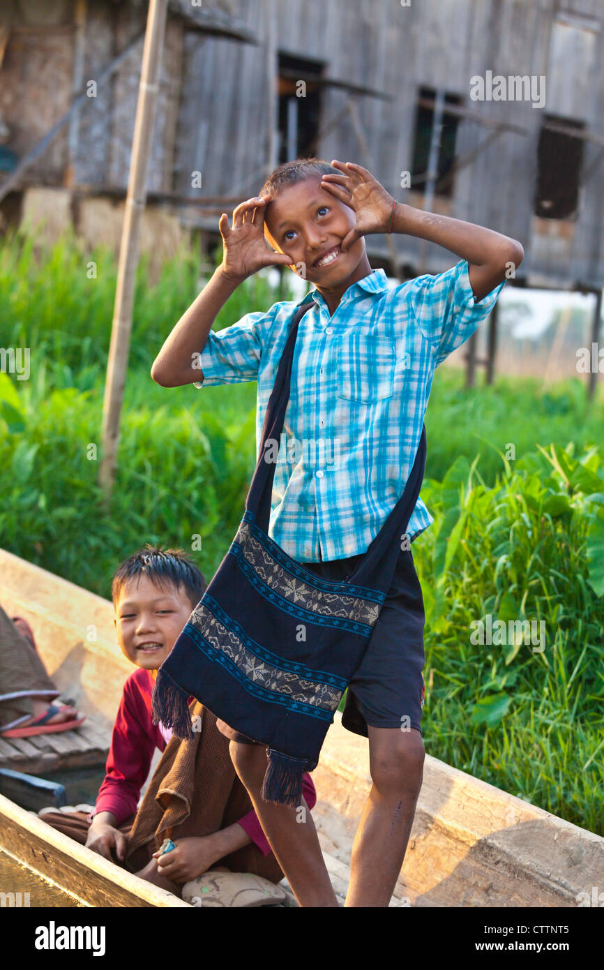 CHILDREN clown around in a boat in the village of PWE SAR KONE - INLE LAKE, MYANMAR Stock Photo