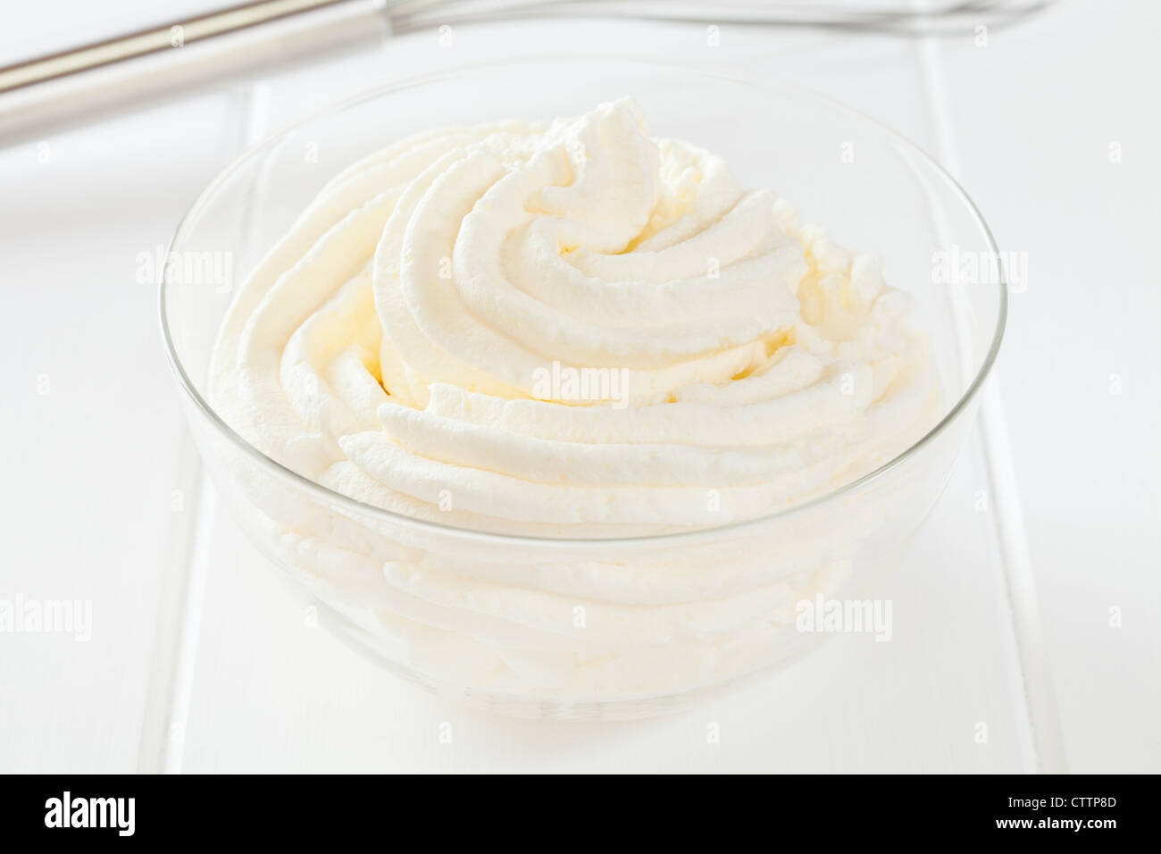 A bowl of whipped cream on a light surface. Stock Photo