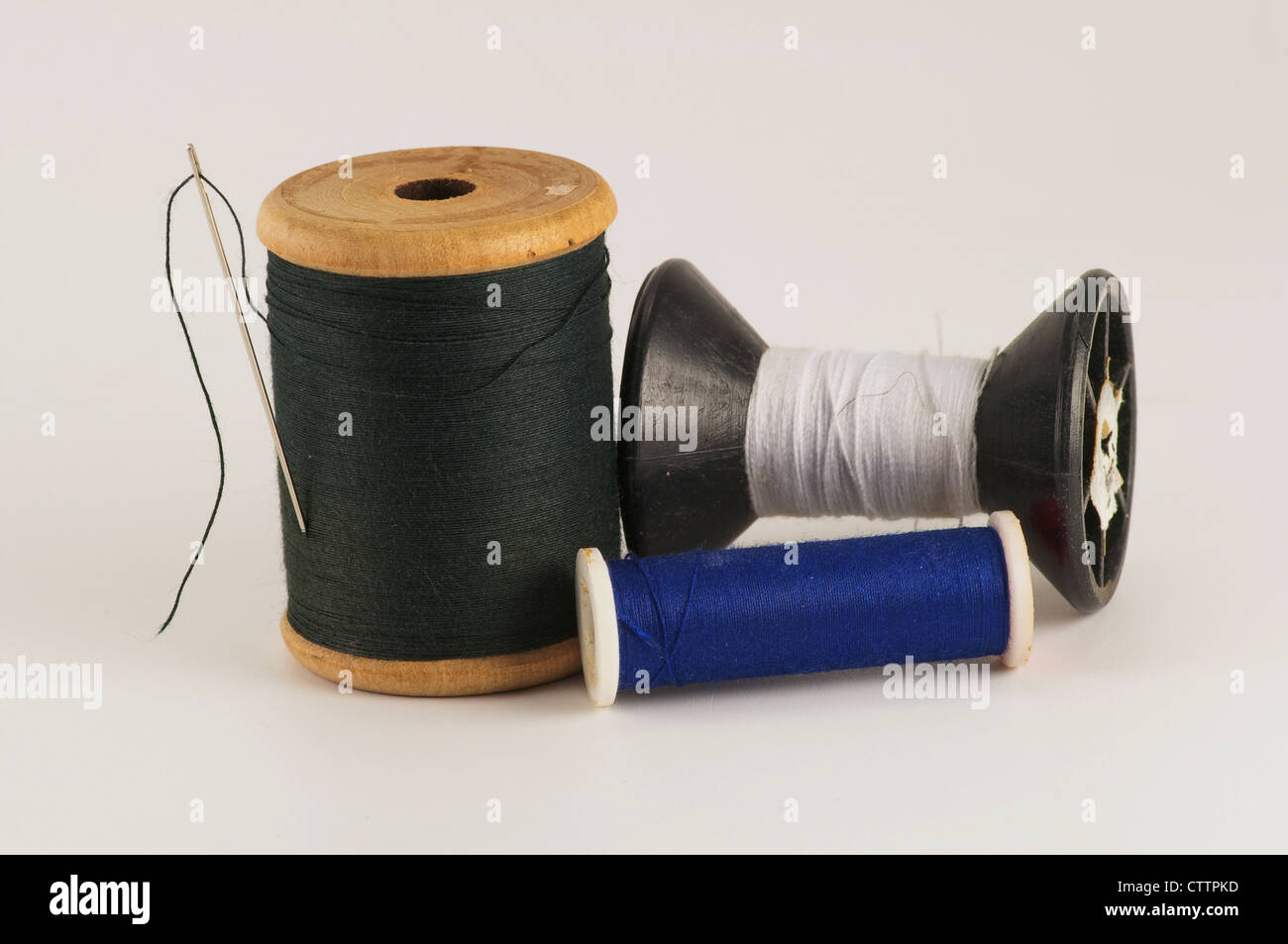 Spool of thread with needle on white background Stock Photo - Alamy