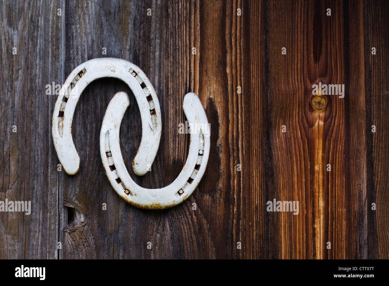Two horseshoes nailed to an old shed door. Stock Photo