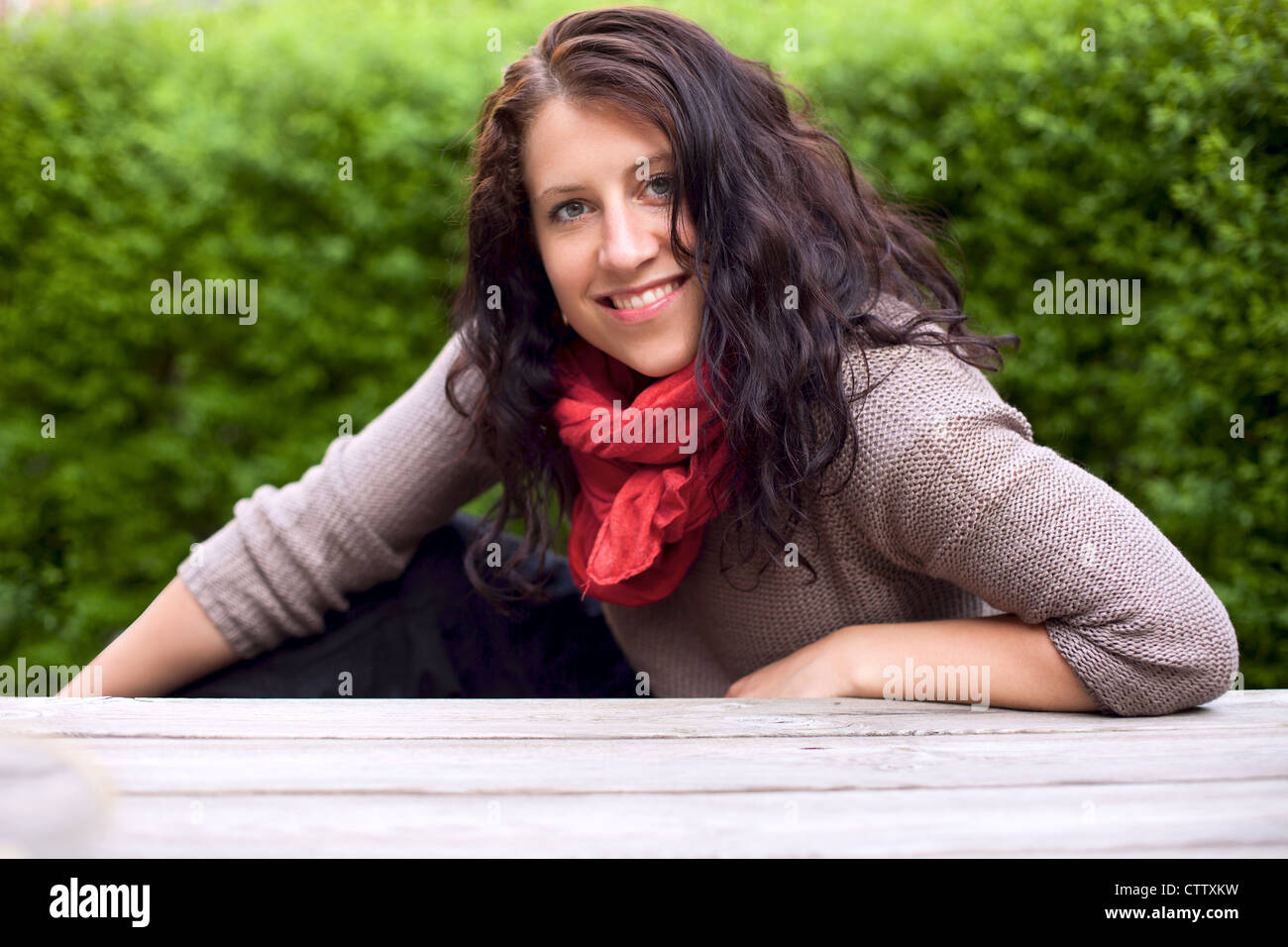 Portrait of a smiling woman in the park posing against the background ...