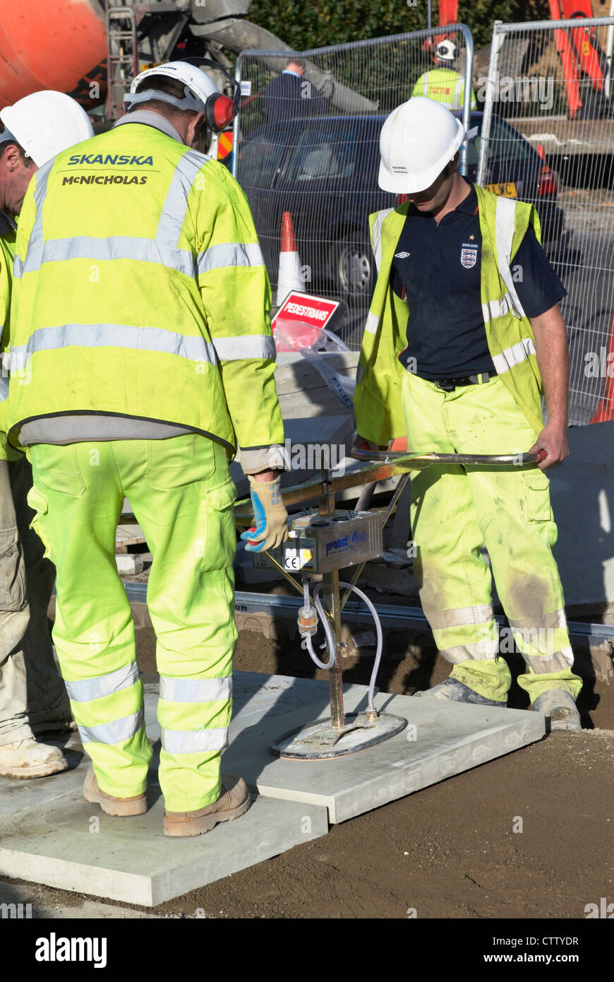 Construction workers using paving stone layer at Westfield London Shopping Centre, Shepherds Bush, London, UK. Stock Photo