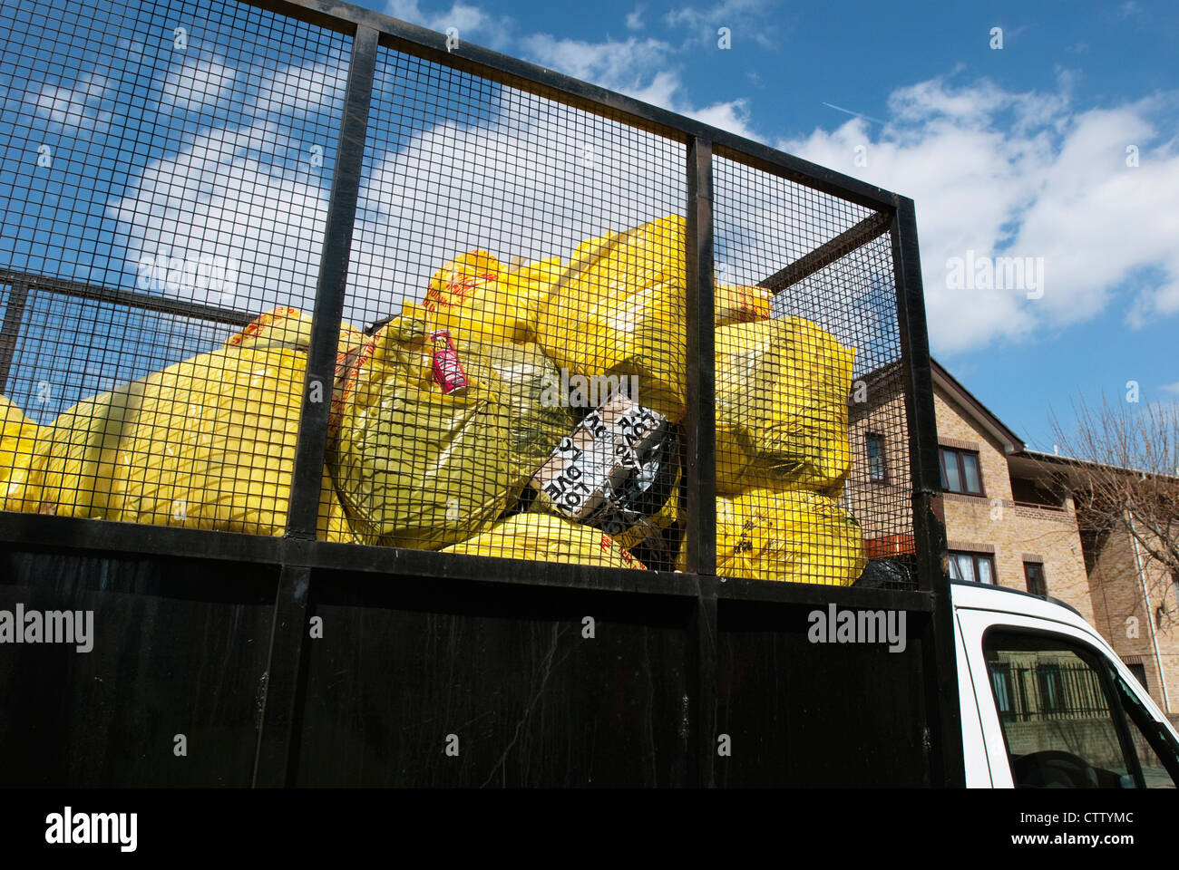 Council lorry picking up waste bags from bins on an estate, South
