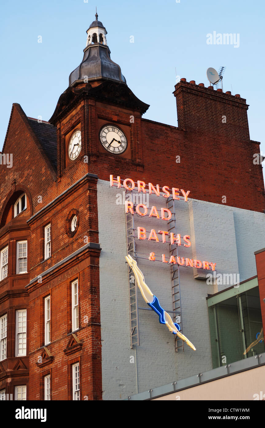 Looking up at a neon sign for the Hornsey Road Baths & Laundry. Stock Photo