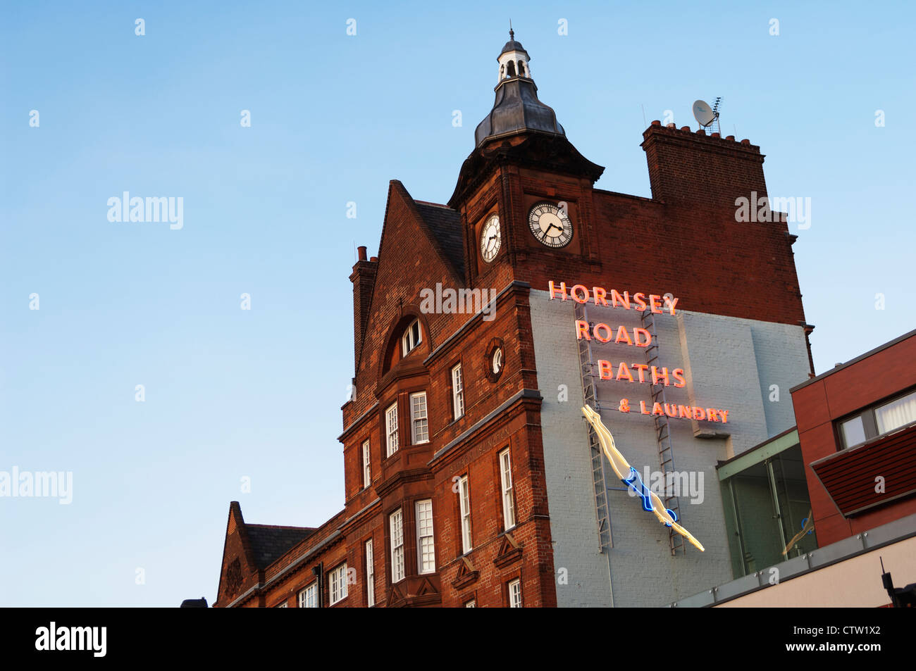 Looking up at a neon sign for the Hornsey Road Baths & Laundry. Stock Photo