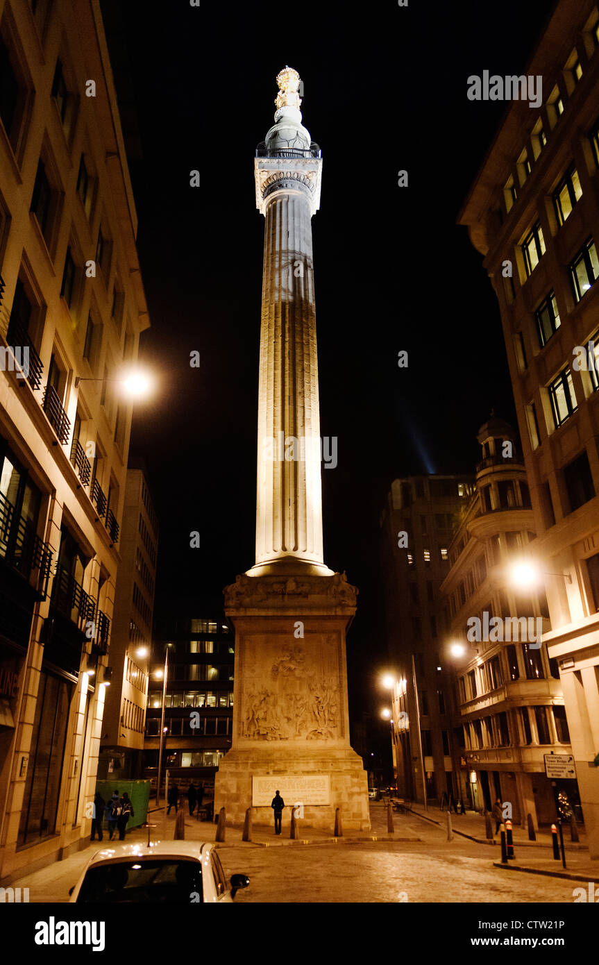 Looking up at the Great Fire of London Monument, by Christopher Wren and Robert Hooke, lit up at