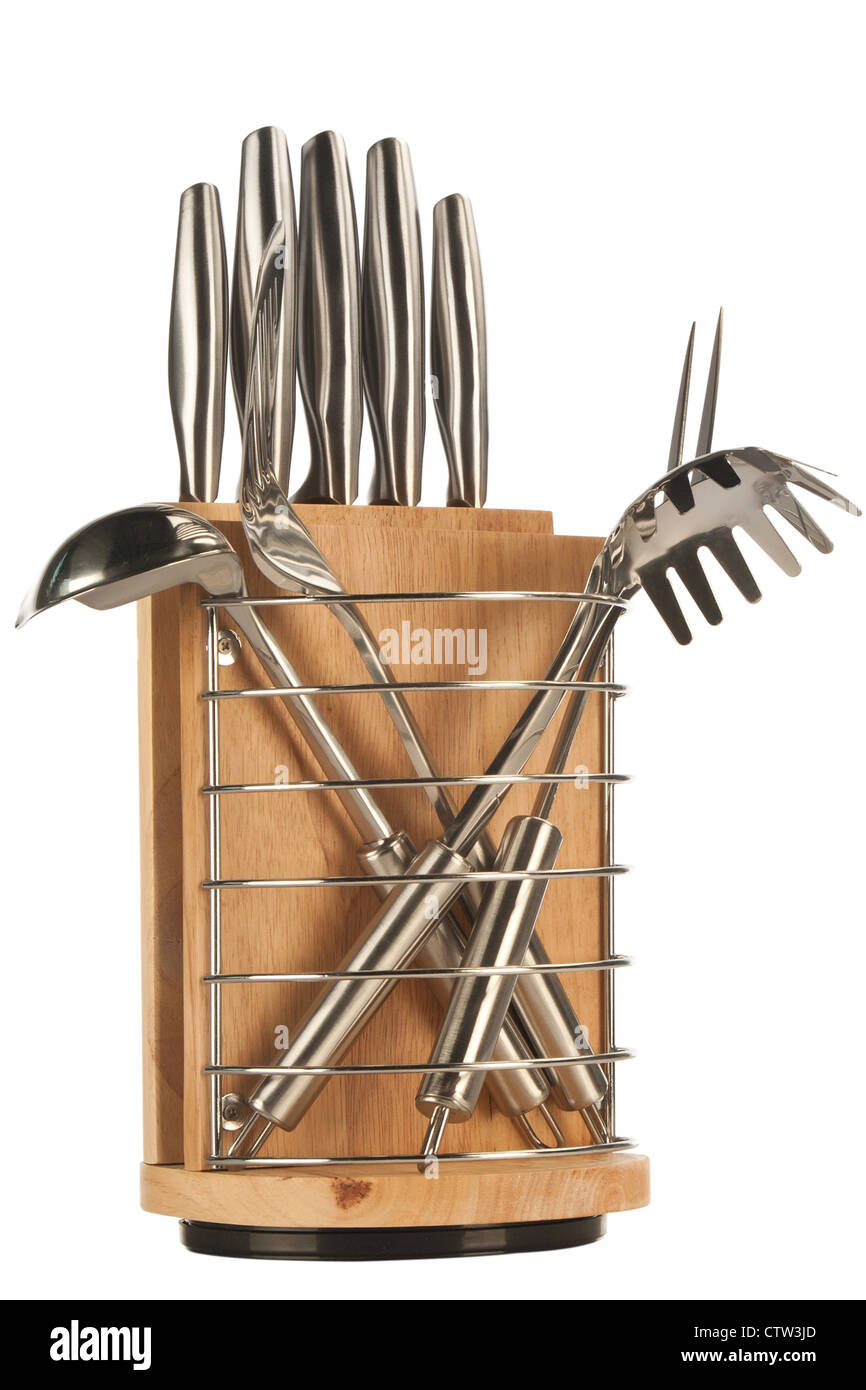 Silver kitchen utensils including whisk, tong and spoon on a white