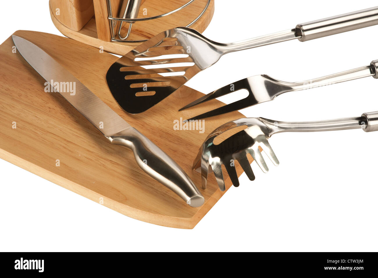 Silver kitchen utensils including whisk, tong and spoon on a white