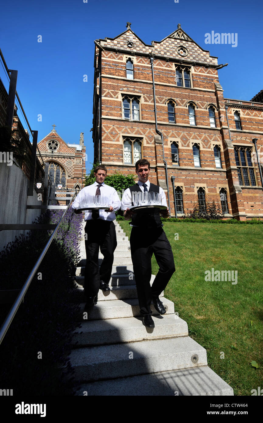 Waiters carry glasses to an event at Keble College at Oxford University