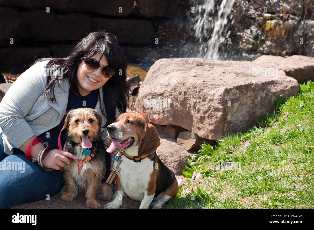 A young woman poses with her two dogs by a waterfall Stock Photo - Alamy
