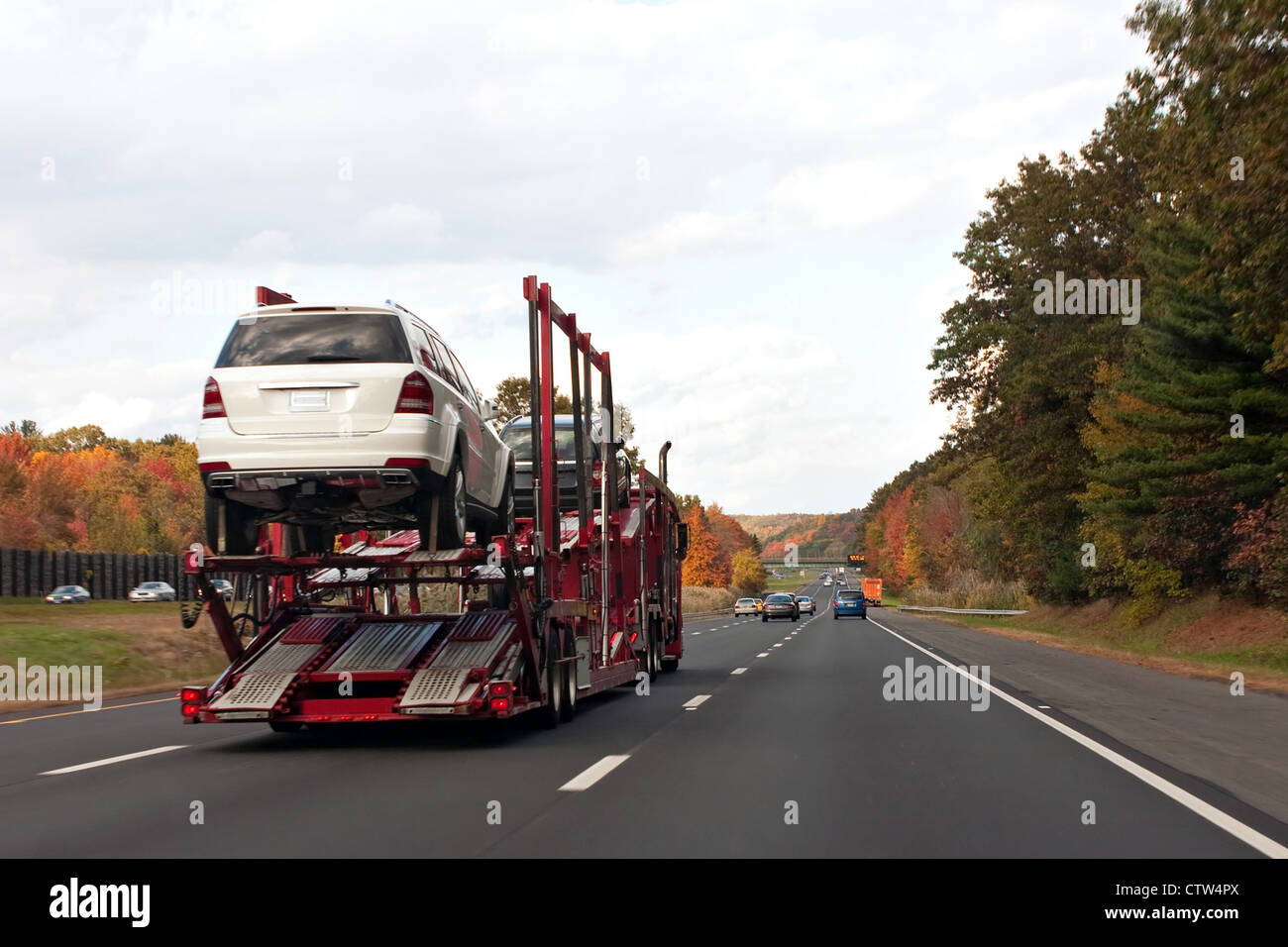 An automotive car carrier truck driving down the highway with a full load of new vehicles. Stock Photo