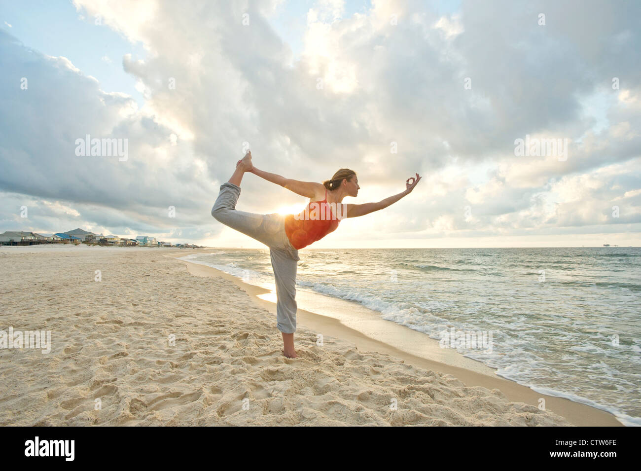A woman practices yoga at sunrise on the beach Stock Photo - Alamy