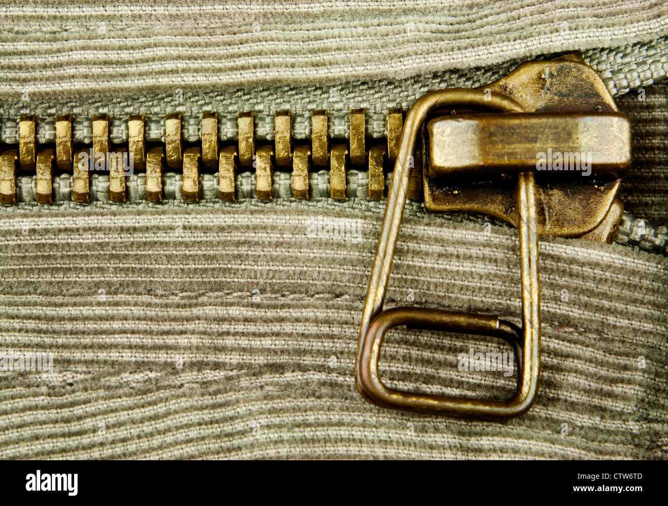 Macro detail of bronze zipper on textured fabric with copy space. Stock Photo
