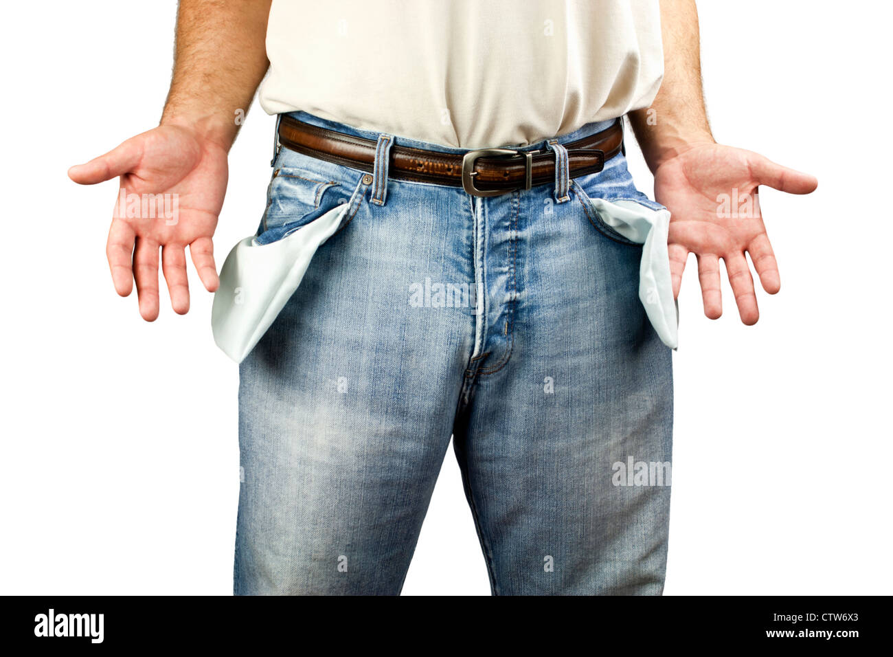 Young unemployed man dressed in blue denim jeans showing empty pockets isolated on white background with copy space. Stock Photo