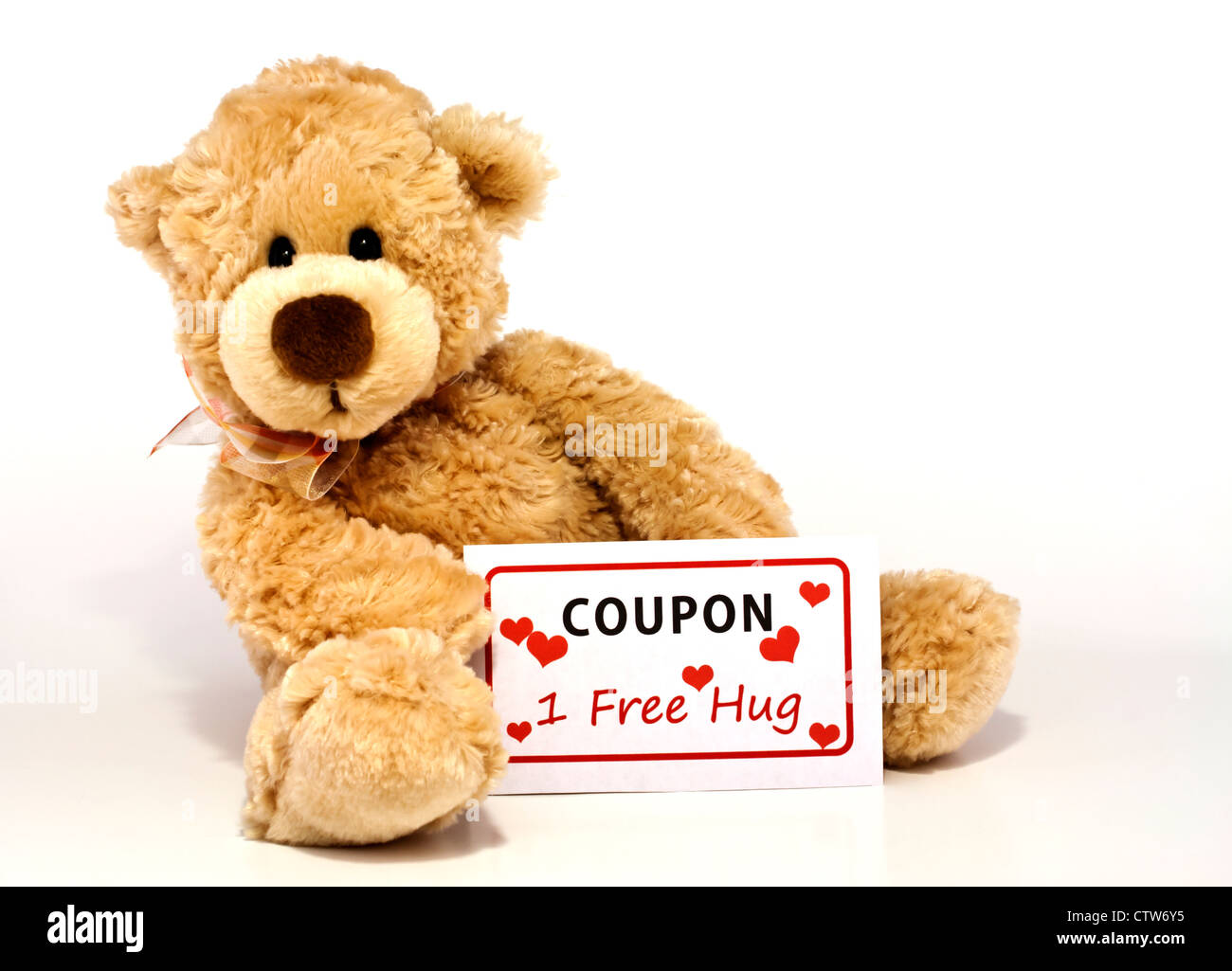 Cute furry brown teddy bear sitting and holding a coupon for one free hug isolated on white background with copy space. Stock Photo