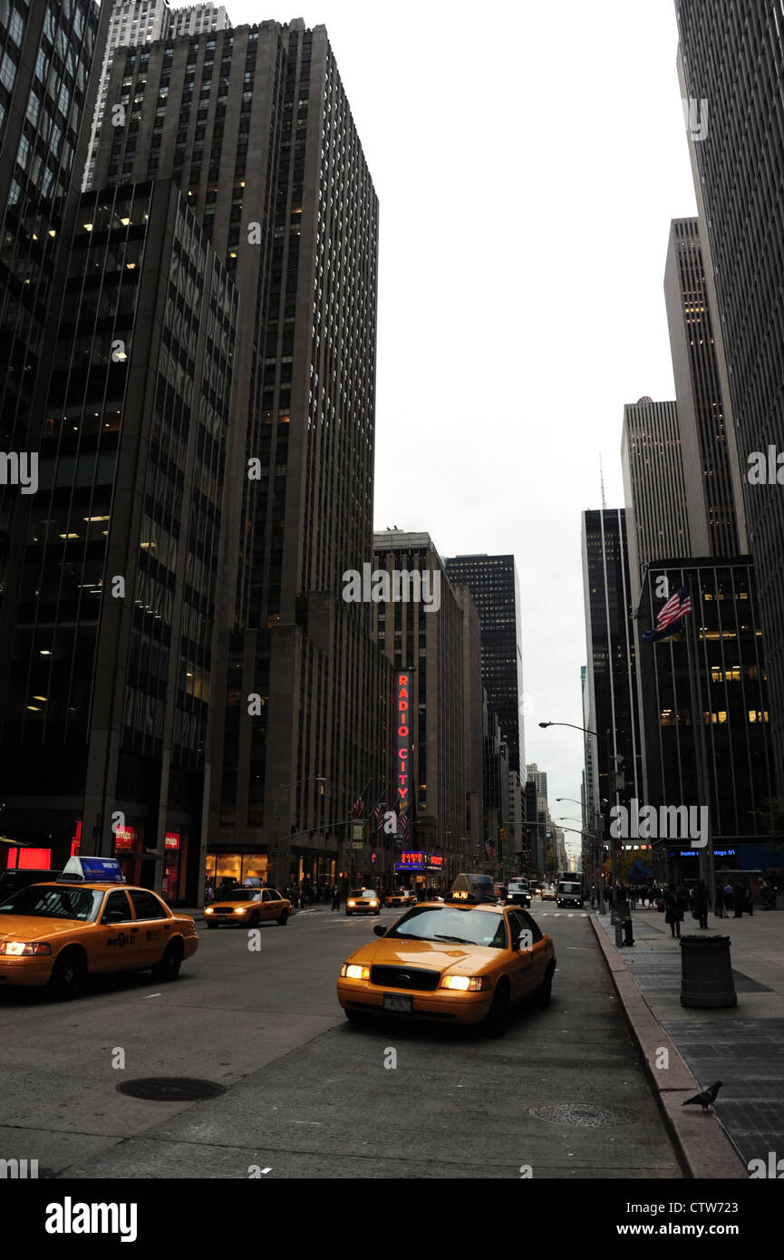 Autumn morning 'urban alley' portrait, to Radio City, yellow taxis headlights shining, 6th Avenue at West 52nd Street, New York Stock Photo