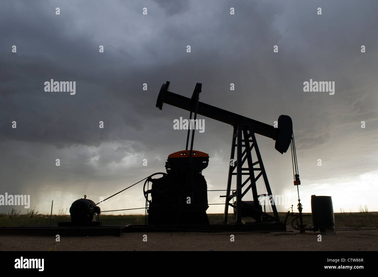 An oil derrick continues to pump during an afternoon thunderstorm near
