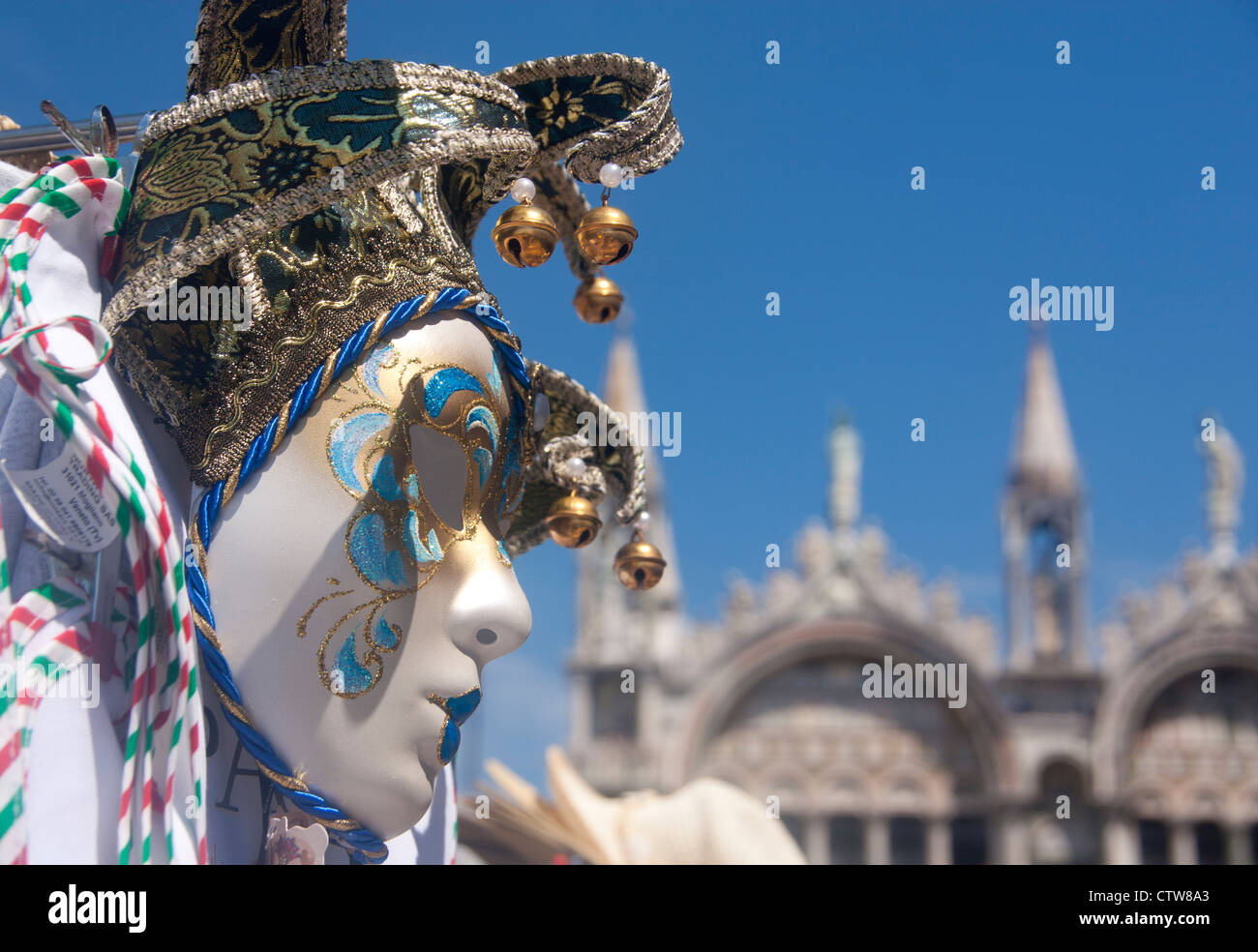 Souvenir Carnival mask on stall in St Mark's Square with St Mark's Basilica out of focus in background Venice Veneto Italy Stock Photo