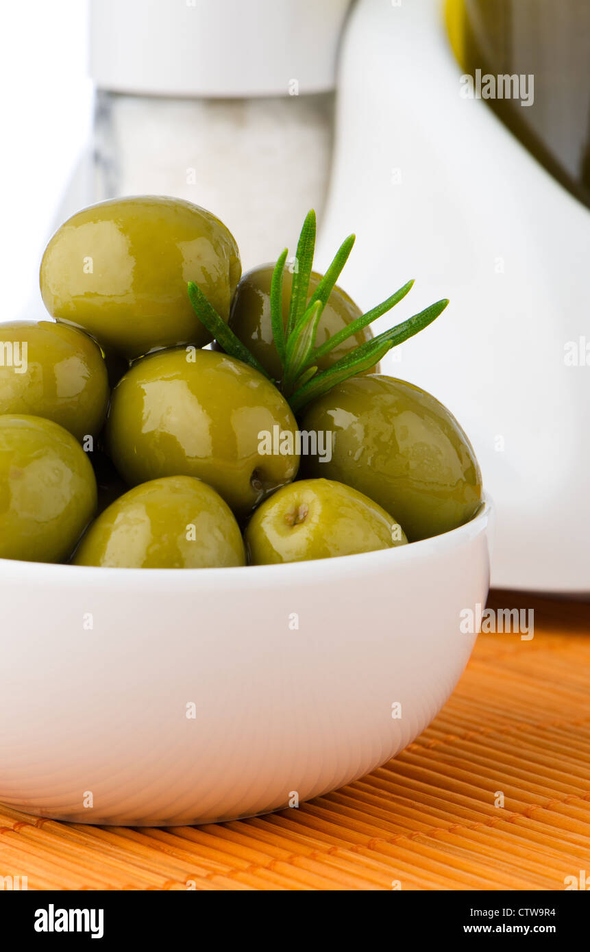 Green olives in a white ceramic bowl and oil decanter set Stock Photo ...