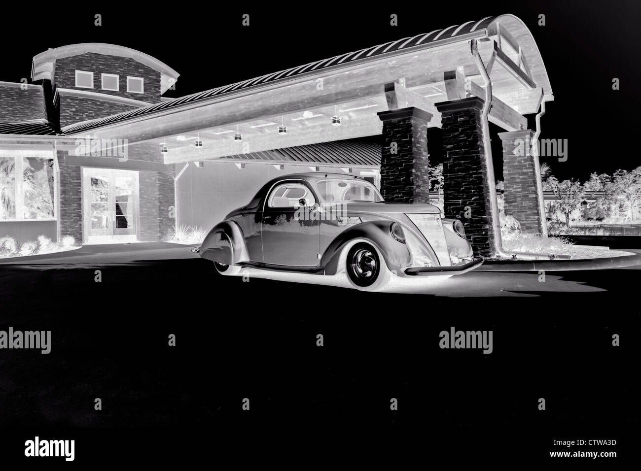 Black and white negative image of classic car and restaurant in The Woodlands, Texas. Stock Photo